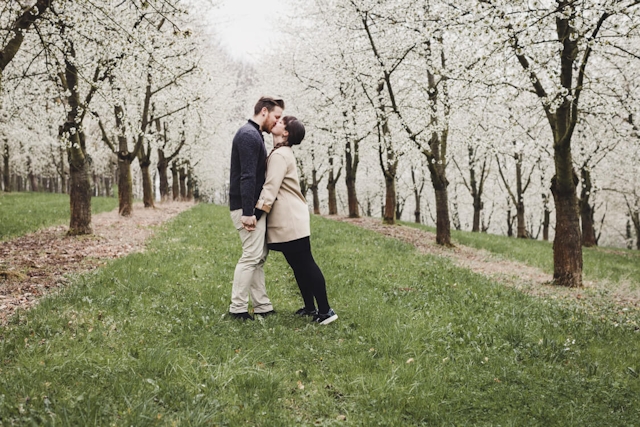 Paar küsst sich in Kirschblüten Allee