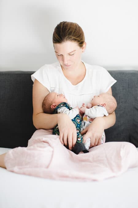 Mutter mit ihren neugeborenen Zwillingen im Arm