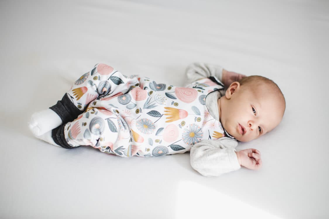 Babymädchen auf dem Bett liegend