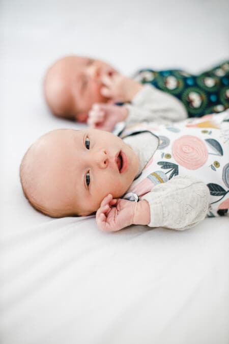 Neugeborenes Mädchen im Vordergrund und der Zwillingsbruder im Hintergrund.