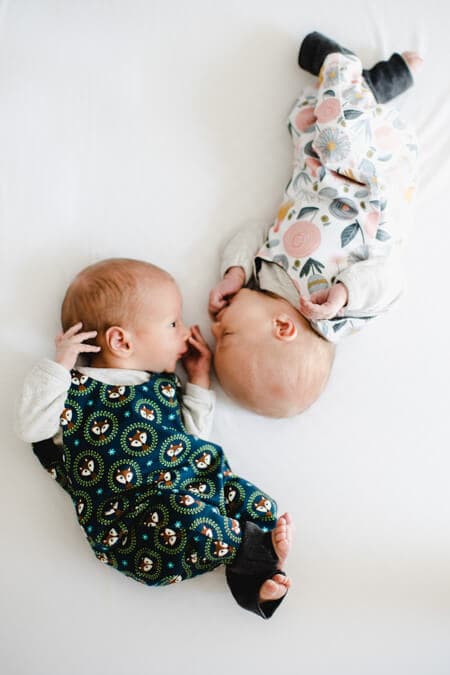 Bilck von oben auf Zwillinge die mit den Köpfen zueinander lliegen