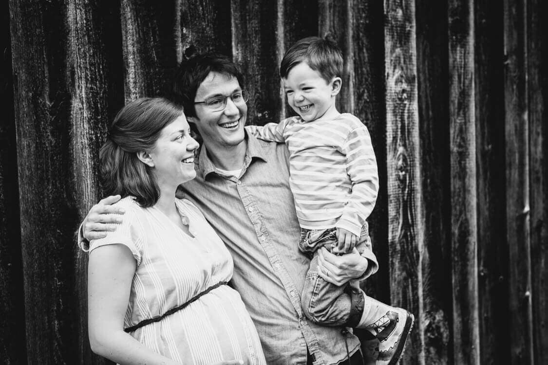 SW Foto von Familie mit kleinem jungen auf dem Arm des Vaters und Babybauch bei der Mutter