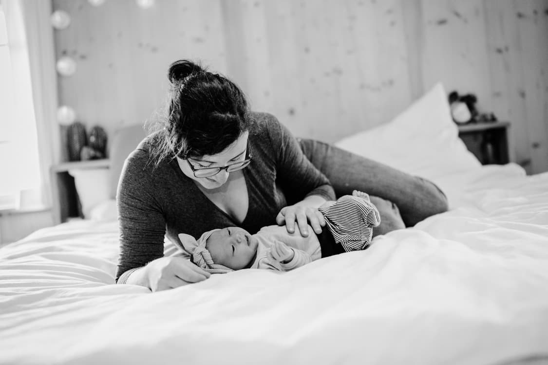 Baby und Mutter liegen auf einem Bett