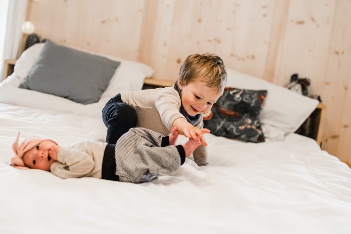 Bruder kitzelt Füße vom Baby