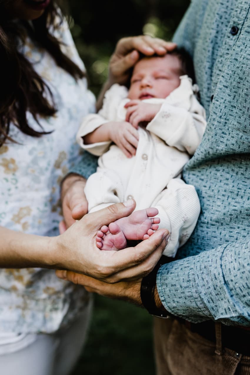 Babyfüße in den Händen der Eltern