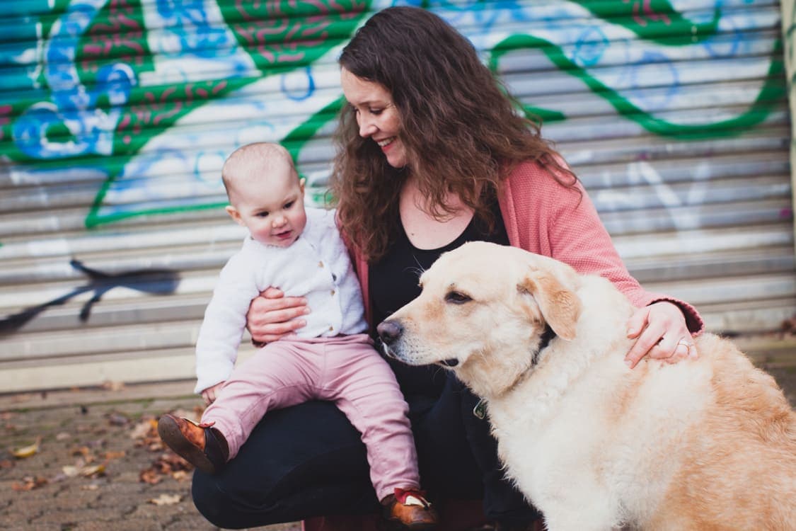 Mama mit Tochter und Hund vor einem Grafiti