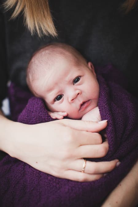 Baby eingepuckt blickt in die Kamera