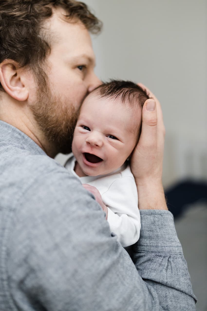 Papa hält sein lachendes Baby auf dem Arm