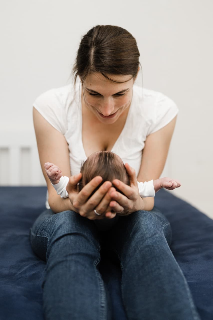 Mutter hält den Kopf ihres Babys