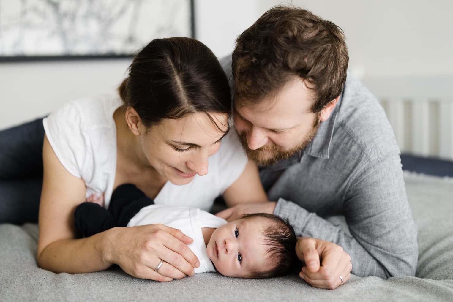 Eltern mit ihrem Baby auf dem Bett