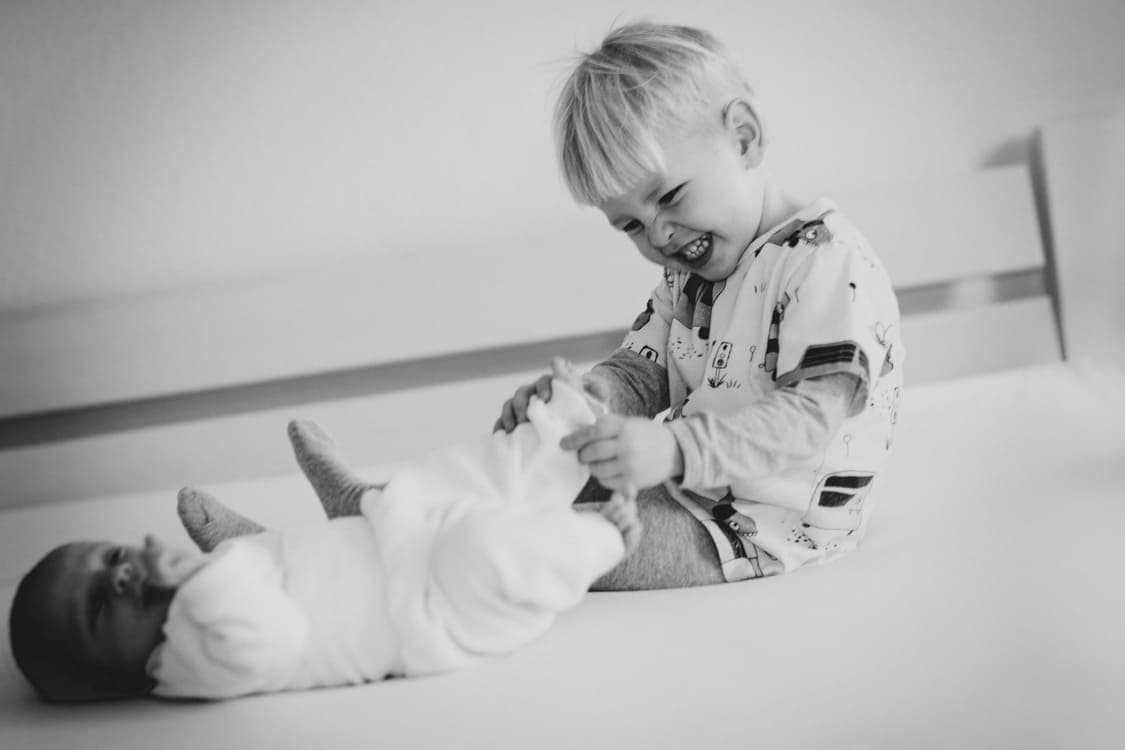 Bruder kitztelt seine Schwester an den Füßen