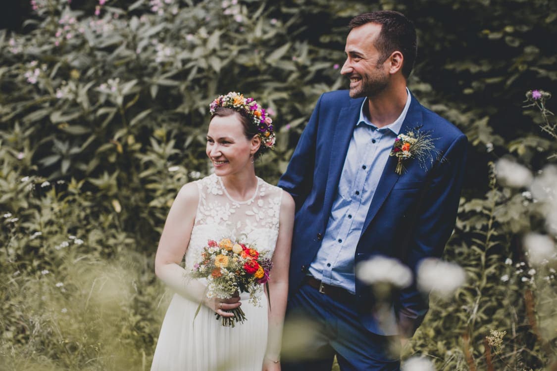 Brautpaar steht locker nebeneinander und schaut zur Seite