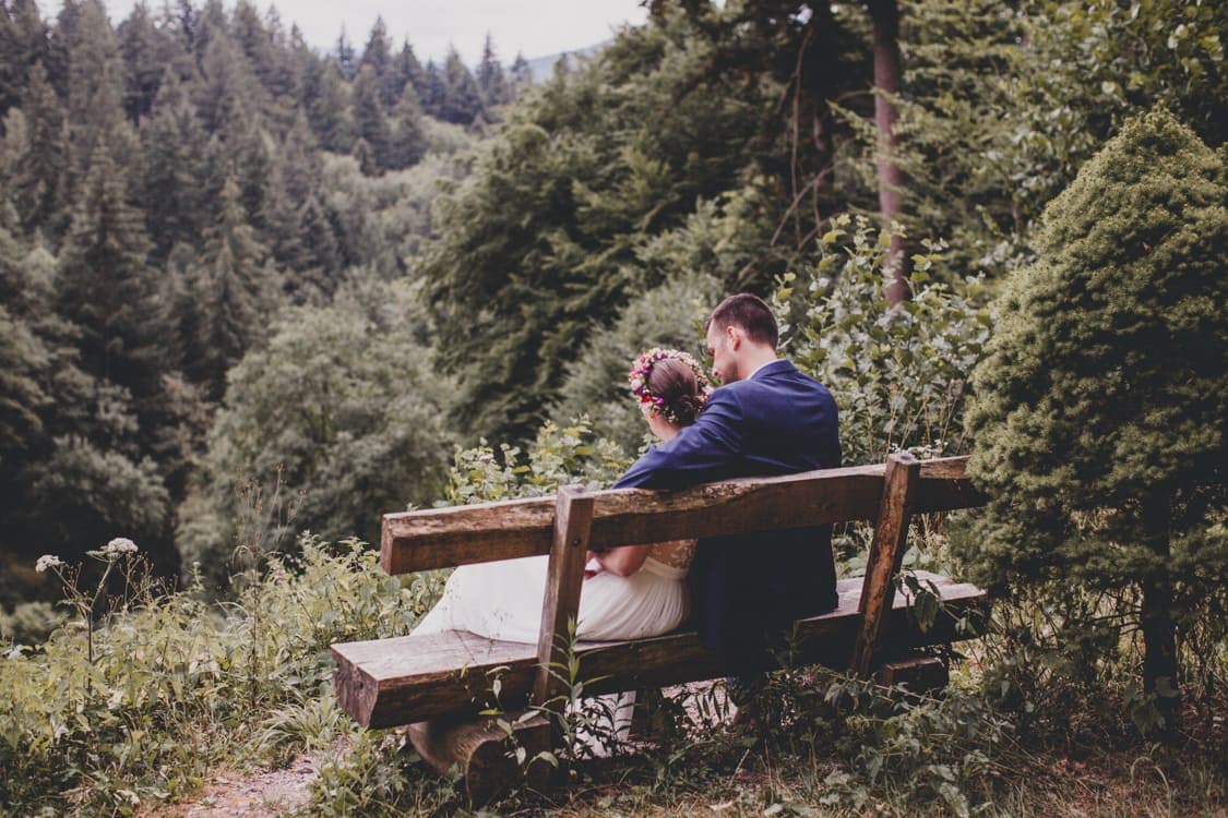 Brautpaar von hinten auf einer bank sitzend
