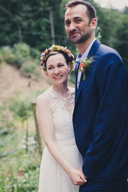 Brautpaar steht zusammen und hält sich an den Händen