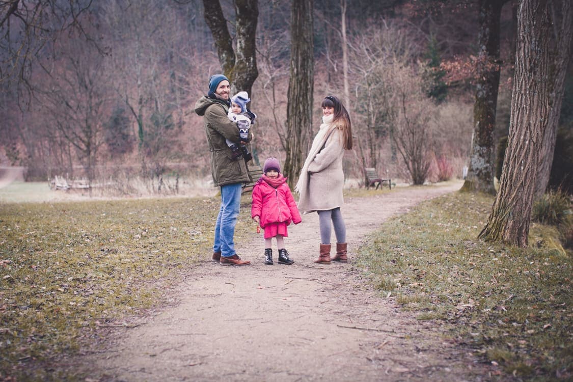 Familie spaziert auf einem Weg und blickt zurück