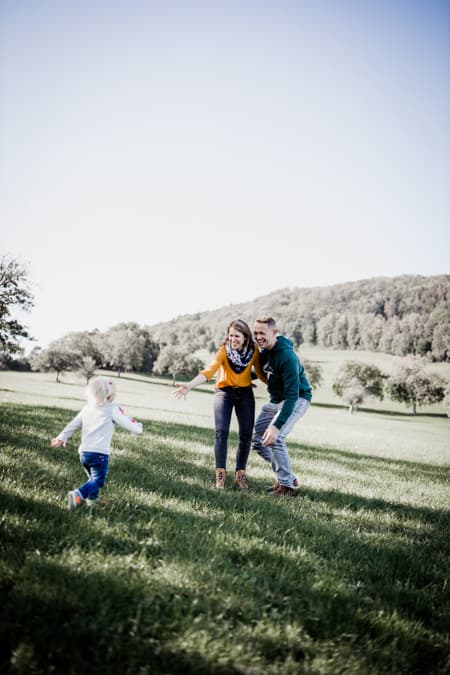 Mädchen rennt in die Arme der Eltern