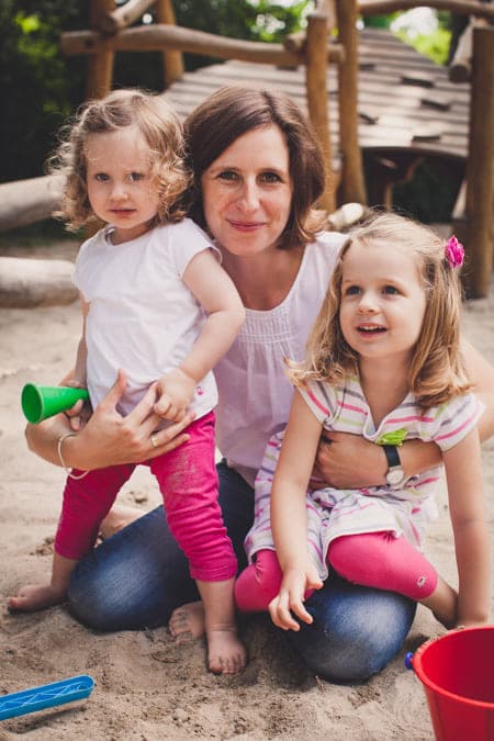 Mutter mit ihren Töchtern im Sandkasten