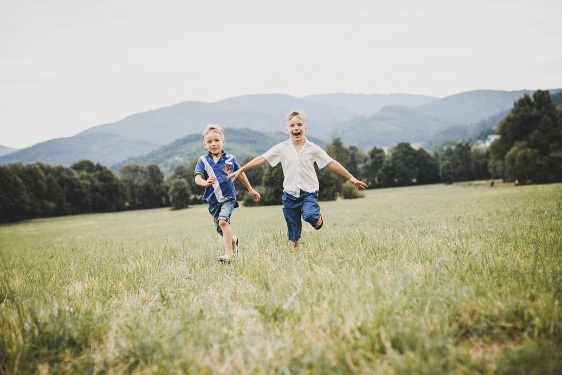 Brüder rennen über eine Wiese