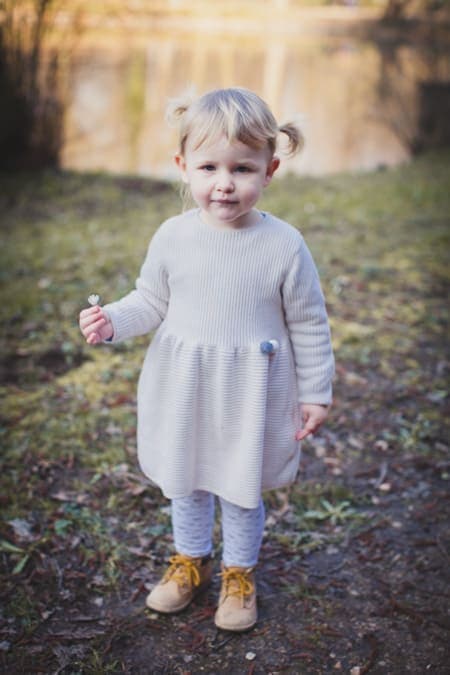 Mädchen mit Zöpfen steht am See