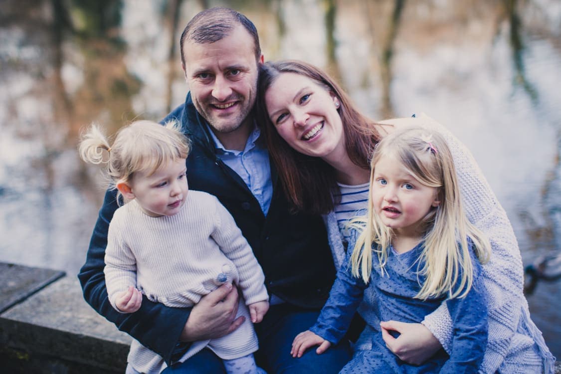Familie mit zwei kleinen Töchtern am See