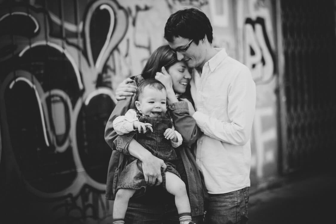 SW Foto von Familie mit Grafiti im Hintergrund