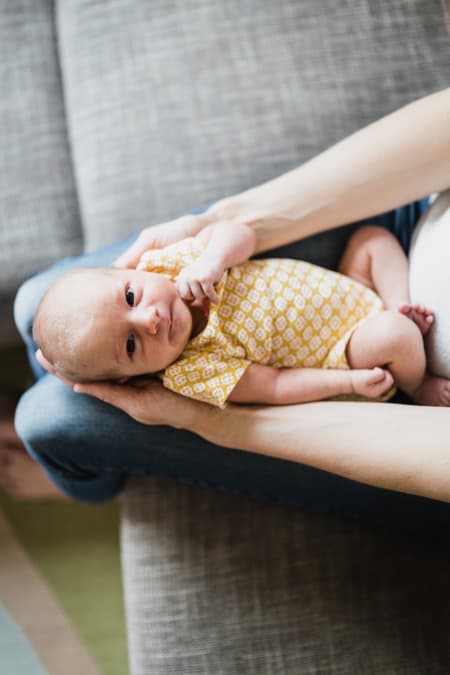 Neugeborenes auf dem Schoß der Mutter