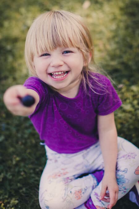 Mädchen streckt einen Stein in richtung der Kamera