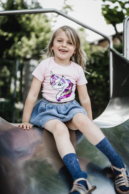 Maedchen sitzt auf Rutsche