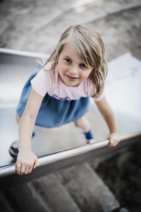 Maedchen steht auf Rutsche