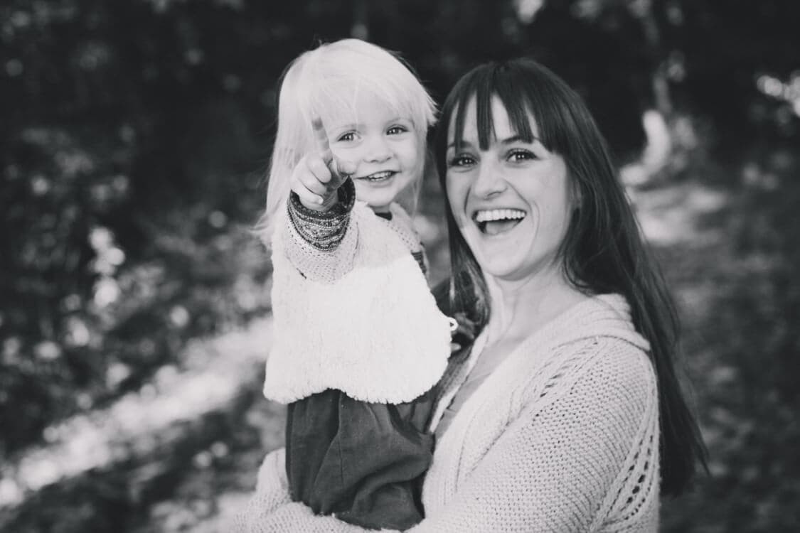 Mädchen auf dem Arm der Mutter zeigt auf etwas