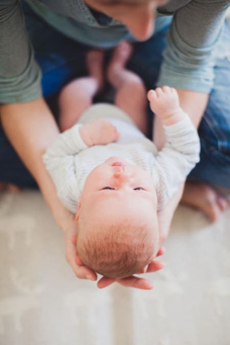 Blick von oben. Mutter hält ihr Baby in den Händen.