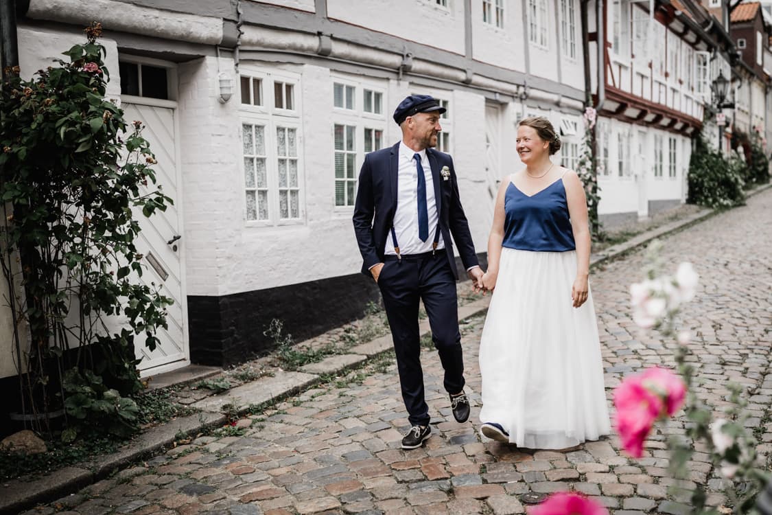 Hochzeitspaar schlendert durch eine schoene Gasse