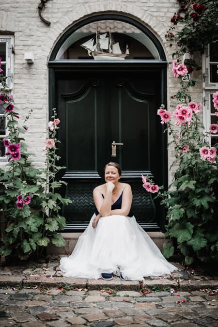 Braut sitzt vor einer Tuere