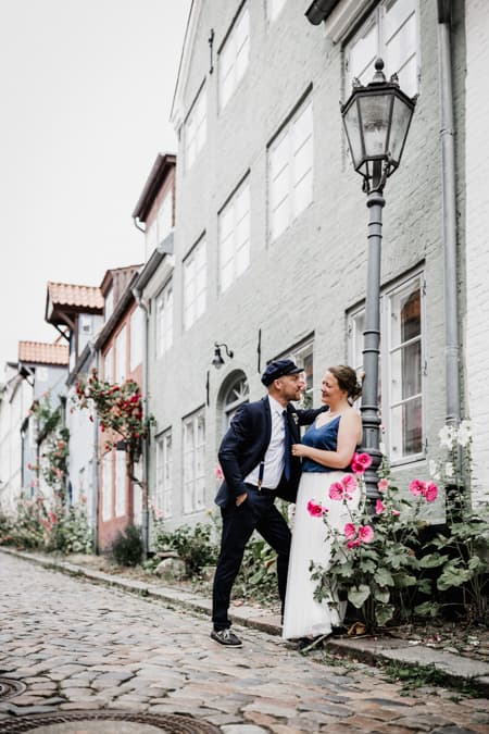 Hochzeitspaar lehnt an eine Laterne