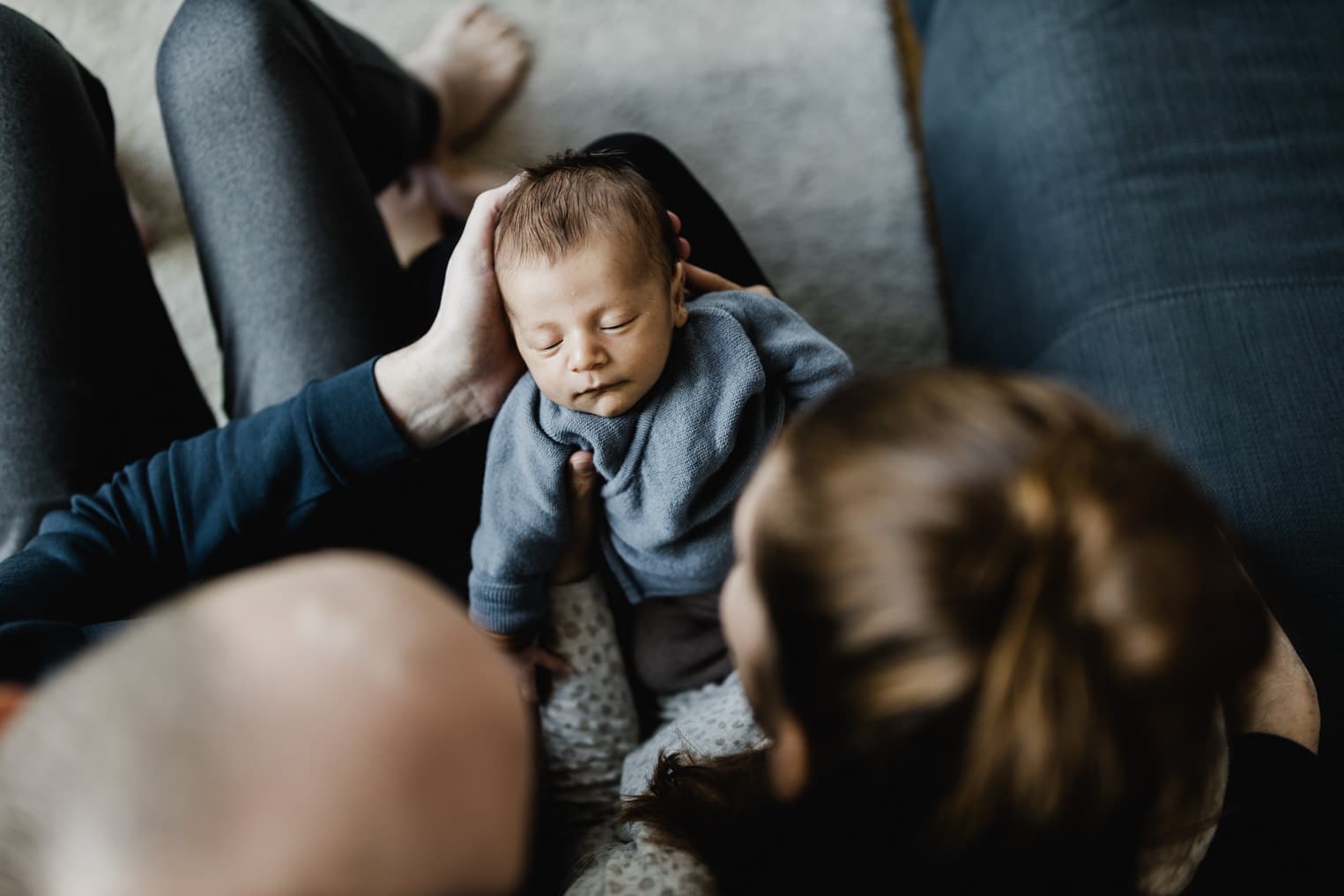 Baby liegt auf dem Schoß der Eltern
