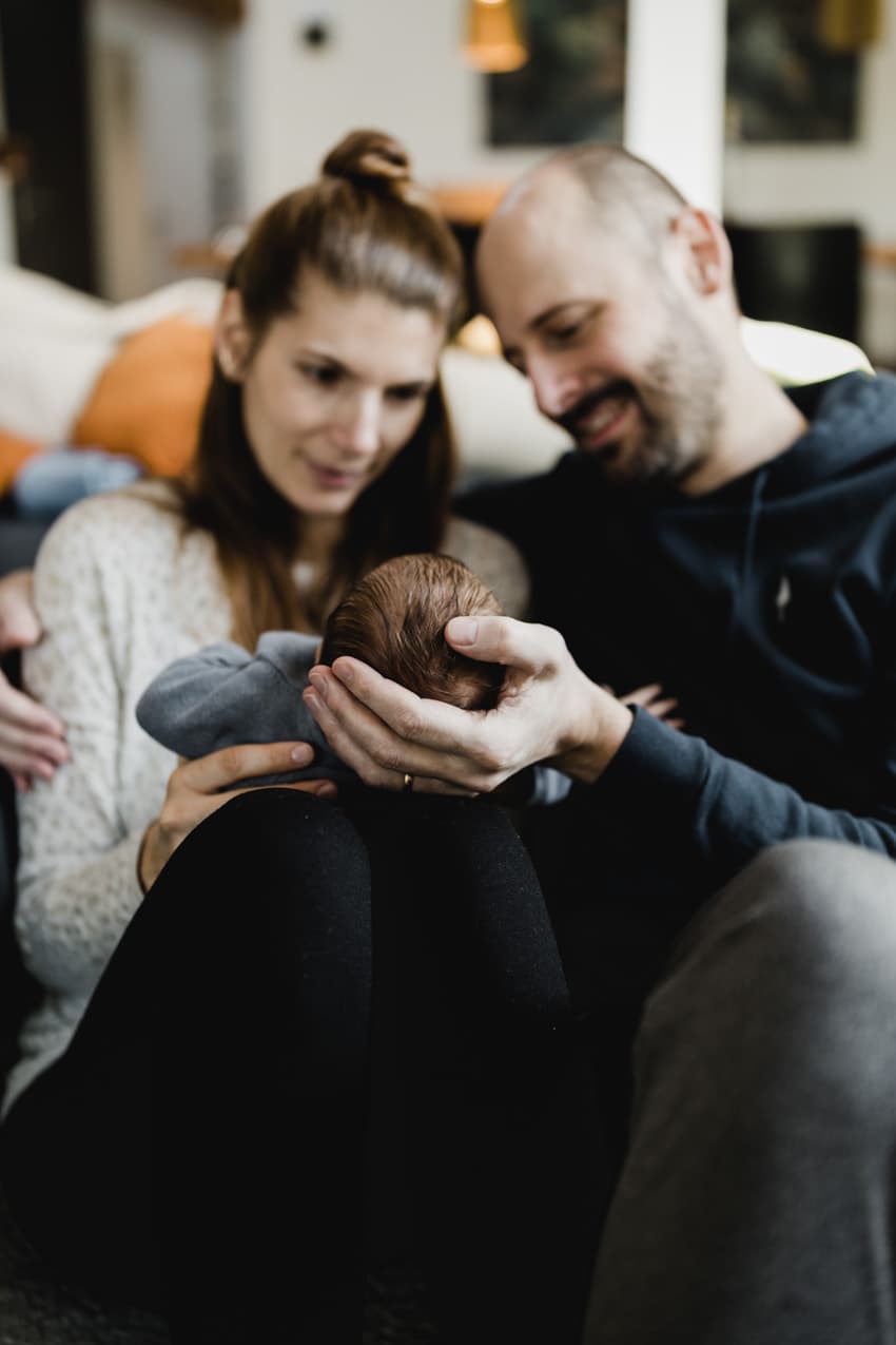 Eltern halten ihr Baby in den Händen