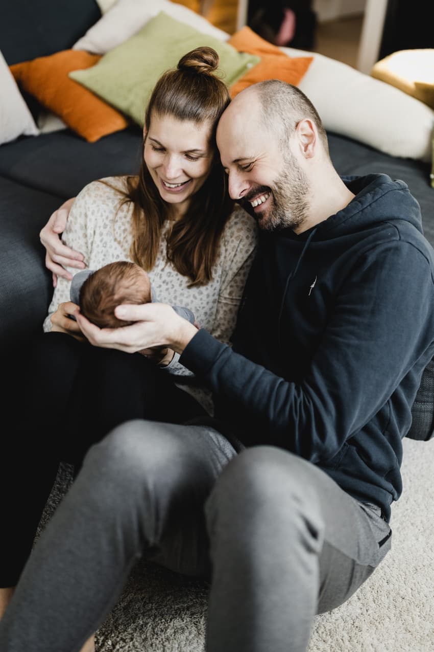 Glückliche Eltern halten ihr Baby in den Händen