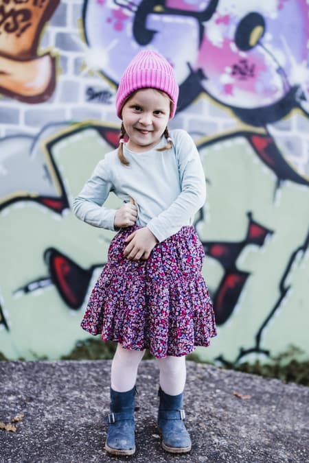 Maedchen mit rosa Mütze vor Graffiti
