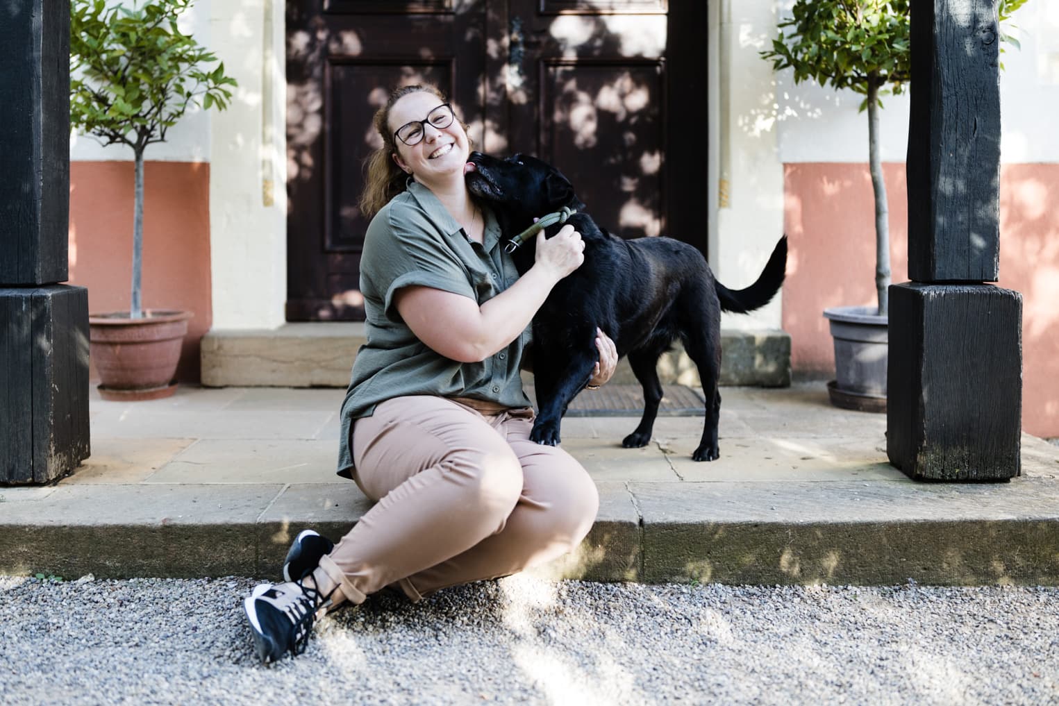 Frau wird von ihrem Hund abgeschleckt