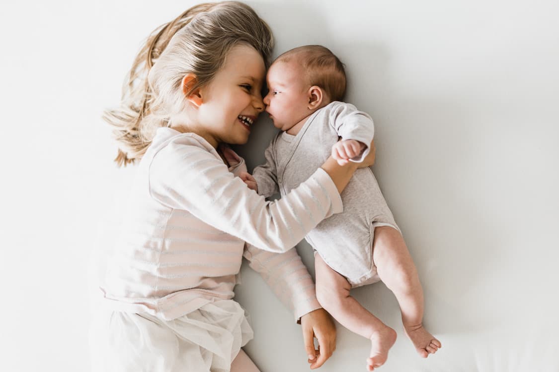 Geschwister liegen Nase an Nase