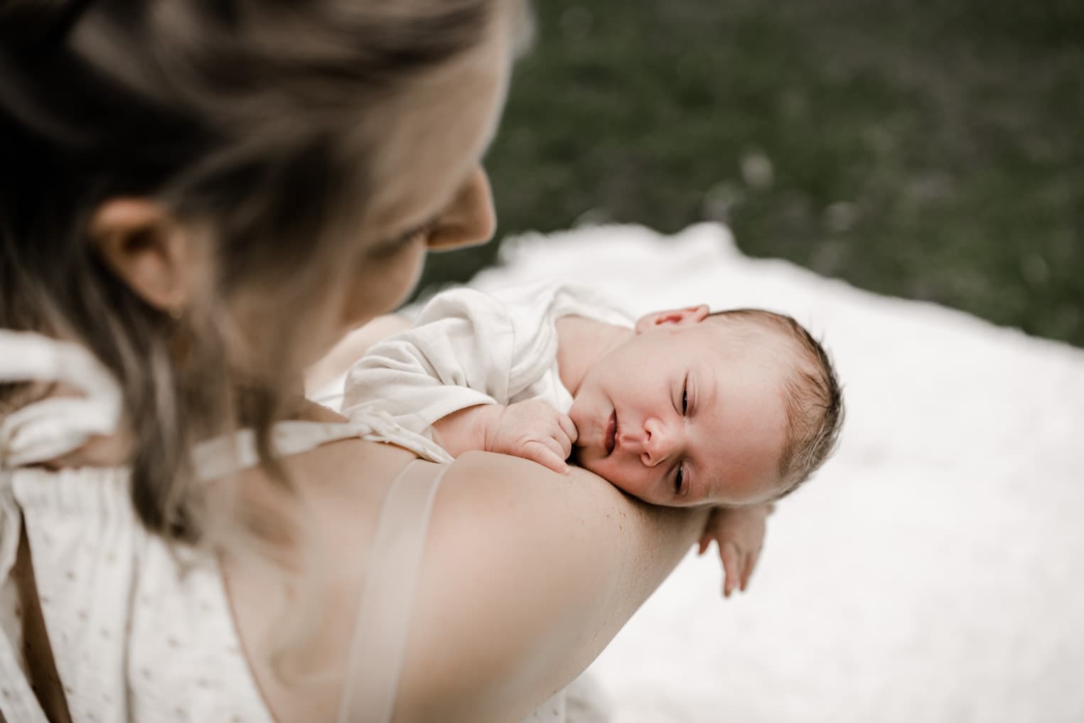 Baby schläft auf dem Arm der Mutter 