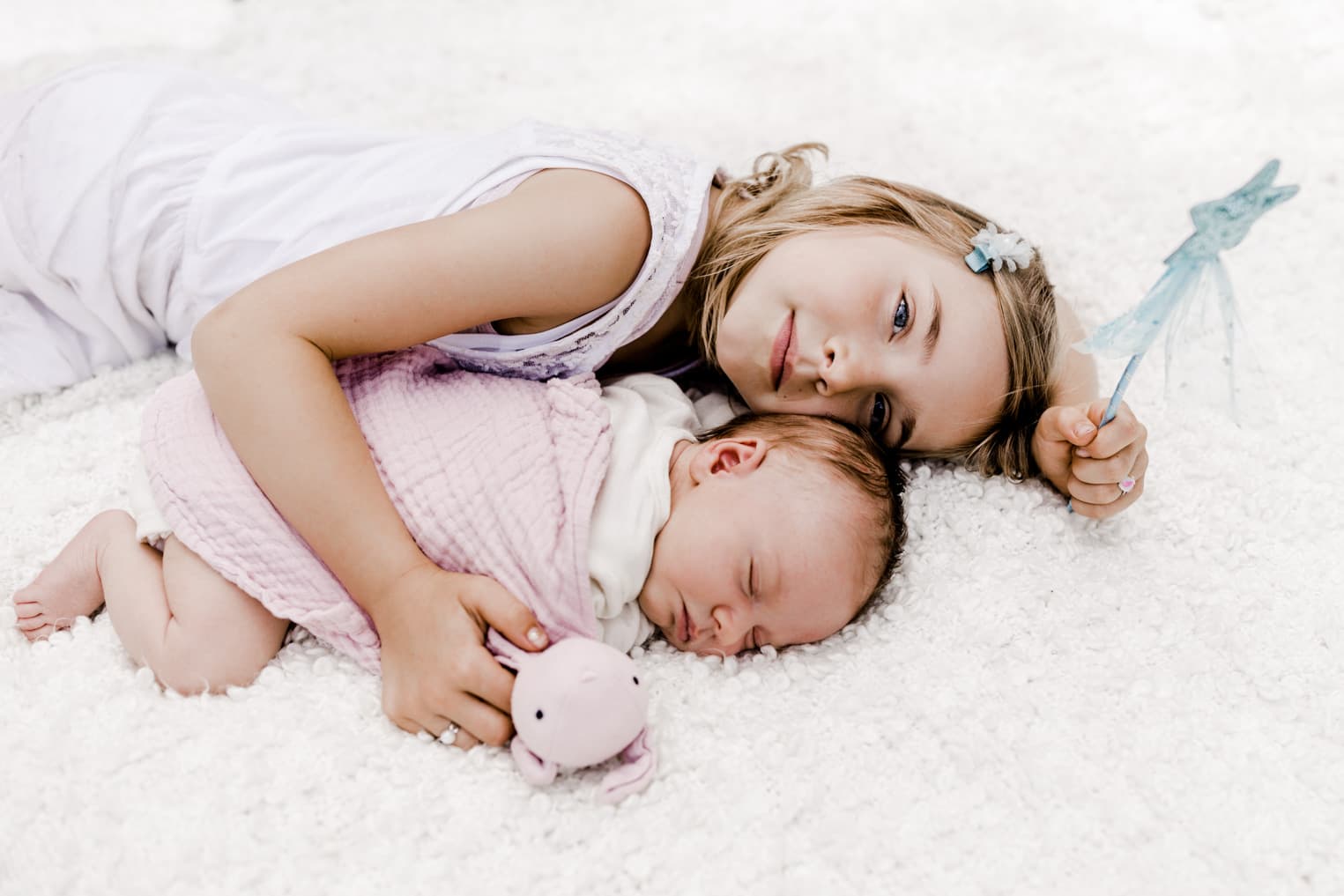 Schwestern kuscheln auf einer Decke