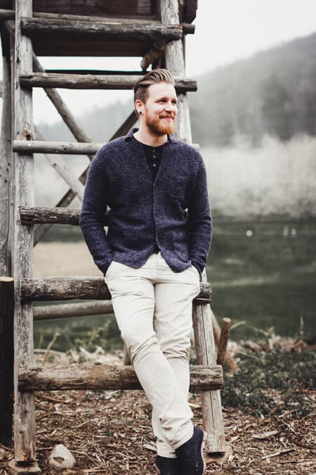 Mann lehnt an Hochsitz