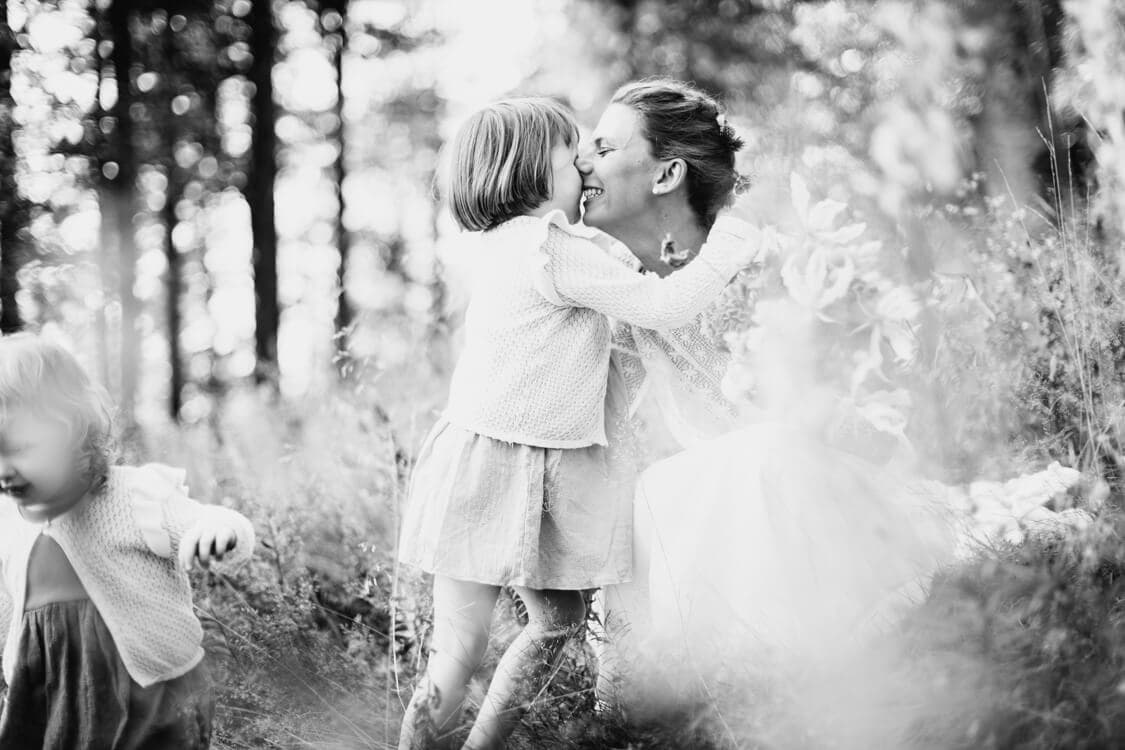 Braut küsst ihre Tochter die sie umarmt