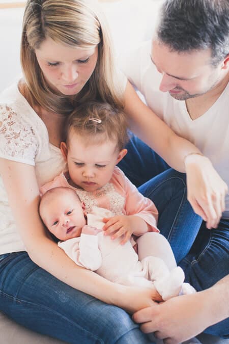 Familie hält Neugeborenes im Arm