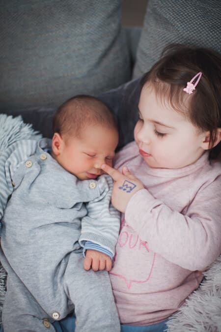 Schwester stupst Bruder an der Nase