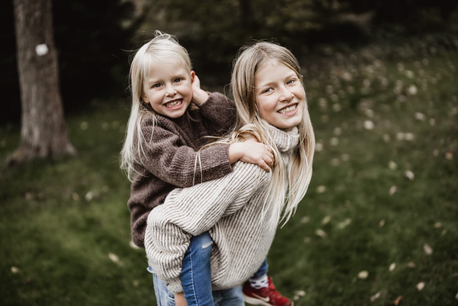Mädchen nimmt Schwester huckepack