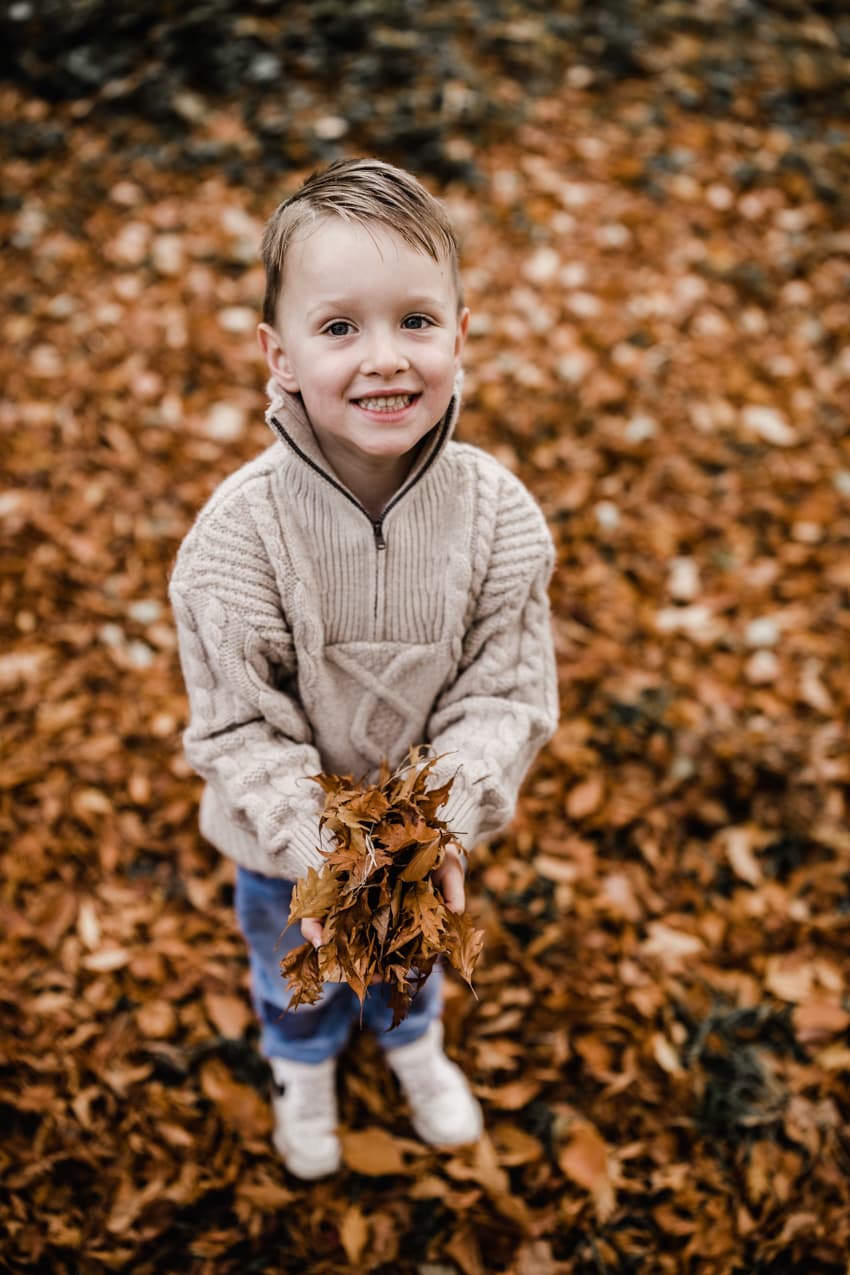 Junge mit Herbstblättern