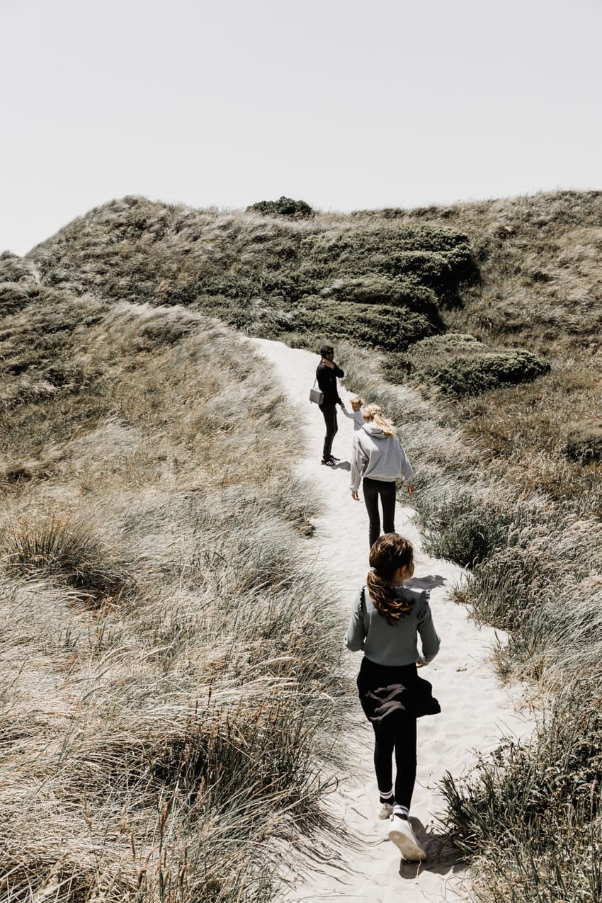 Familie läuft durch die Dünen