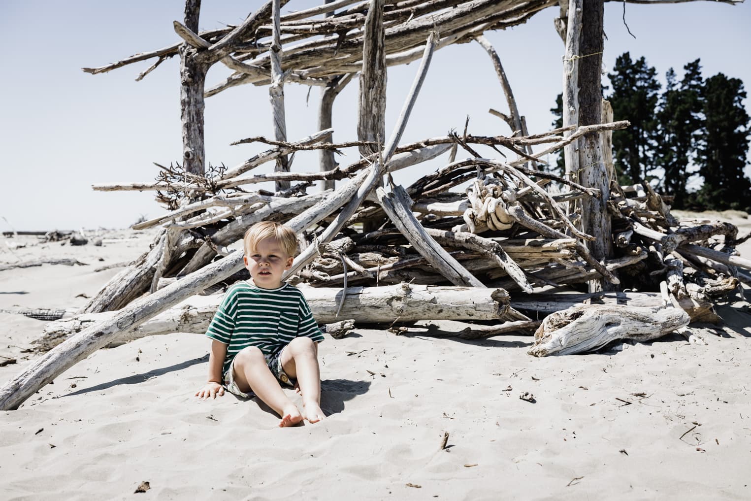 Junge sitzt am Strand